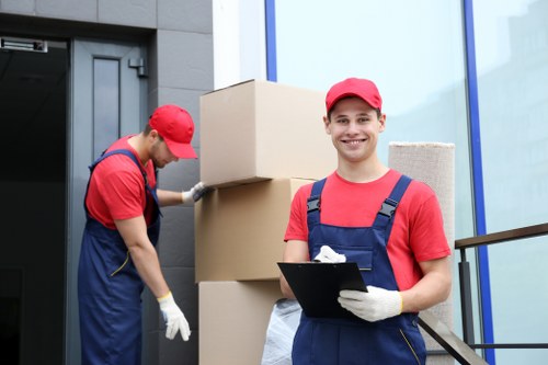 Man with a van loading household items into a moving vehicle