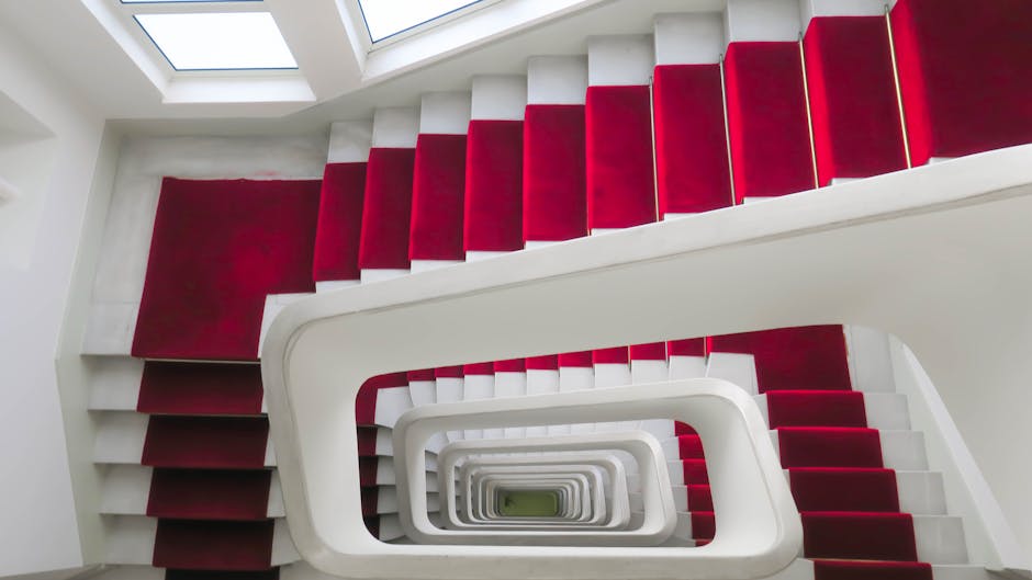 Photograph showing a narrow staircase inside a residential property, viewed from the ground floor. The staircase comprises wooden steps with visible wear, leading upwards into an unseen upper level. T